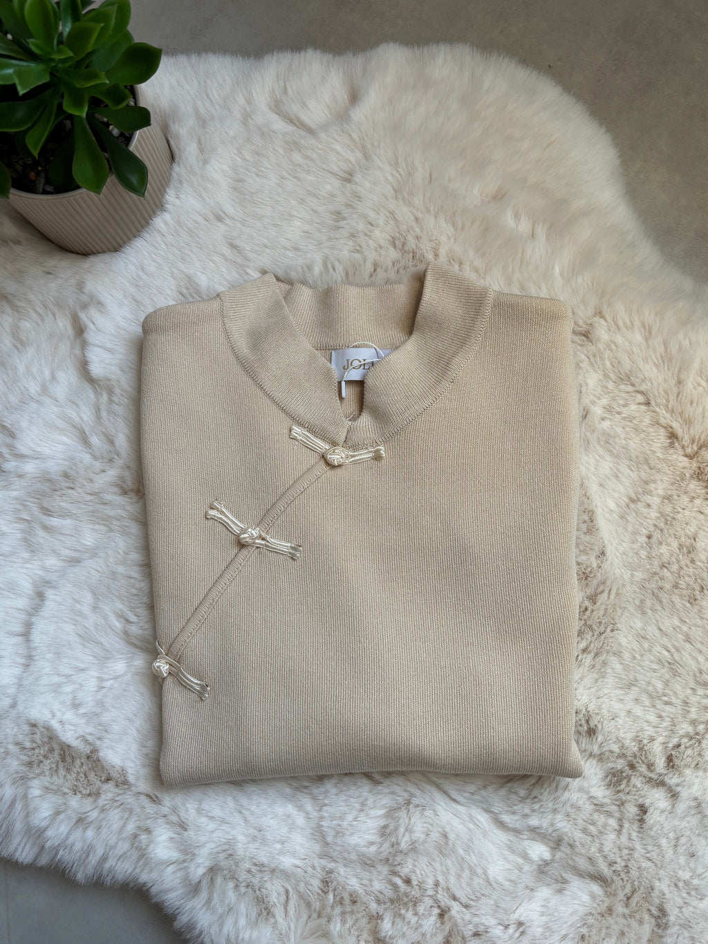 Pull col montant beige à nœuds brandebourgs